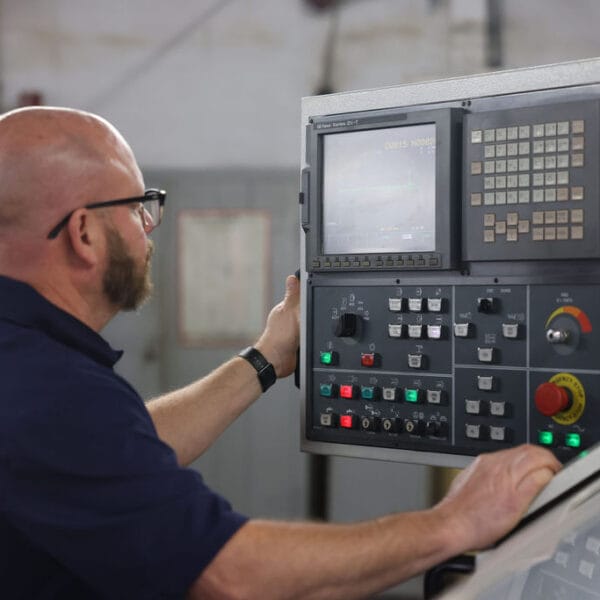 An Quad Industries employee using machinery to complete the process of bearing production.