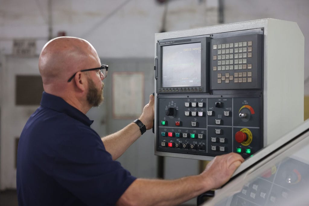An Quad Industries employee using machinery to complete the process of bearing production.